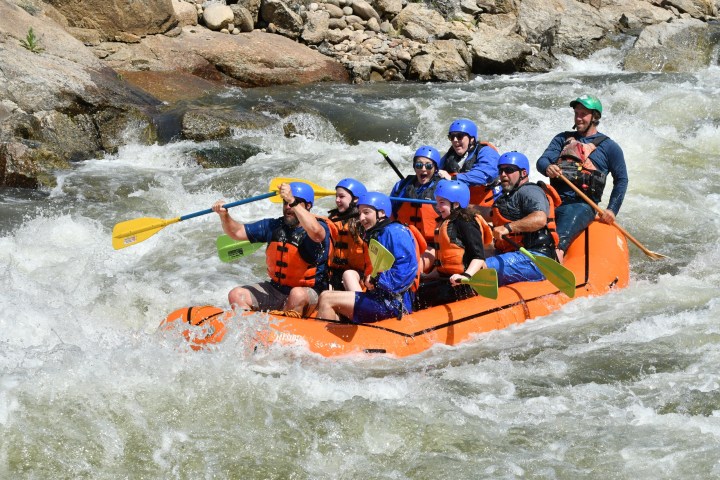 a group of people riding on a raft in the water