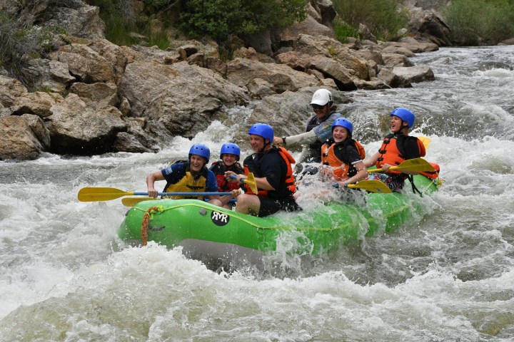 a group of people riding on a raft in the water