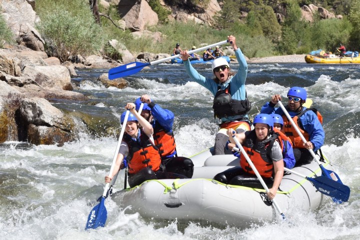 a group of people riding on a raft in the water